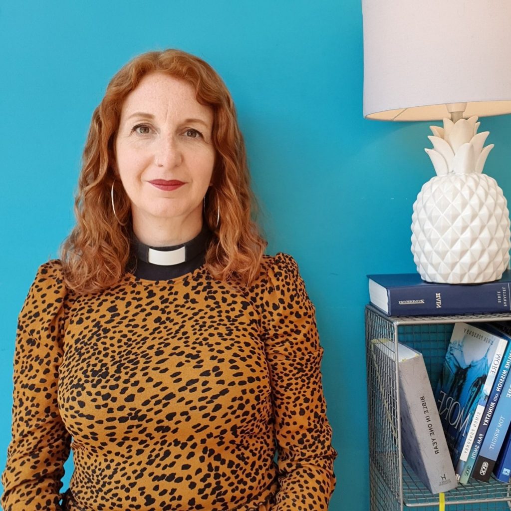 Picture of Jules in spotty dress, against a turquoise background.