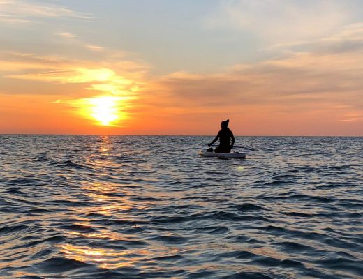 Paddleboarder in front of sunset