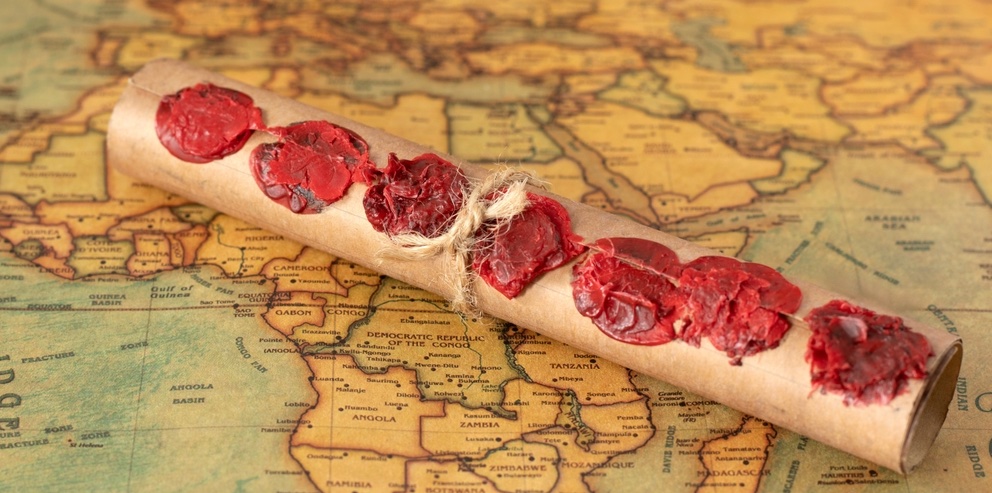 Scroll sealed with 7 red seals, on a background of an old map of Africa and Asia